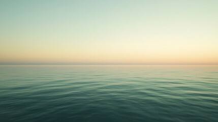 Fototapeta premium A serene image of a calm ocean at sunset, showcasing gentle waves and a pastel sky blending warm and cool colors.