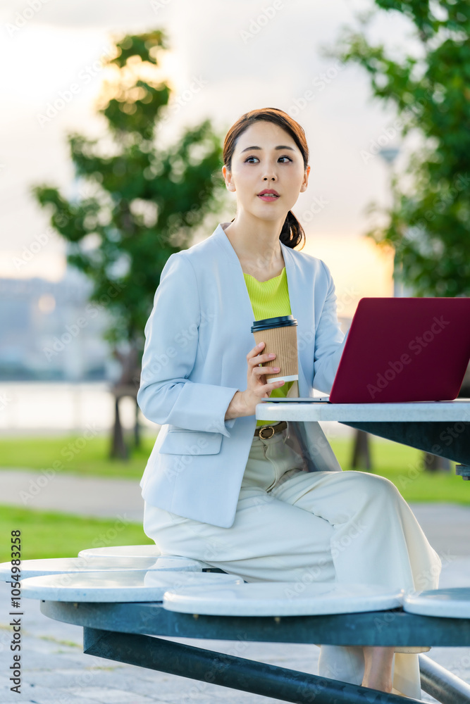 Poster 女性、テラス、カフェ、ノートパソコン、日本人、屋外、公園、パソコン、ノートpc、ワーケーション、ノマド、フリーランス、リラックス、インターネット、オンライン、web、都市、社会、都会、休憩、見上げる、