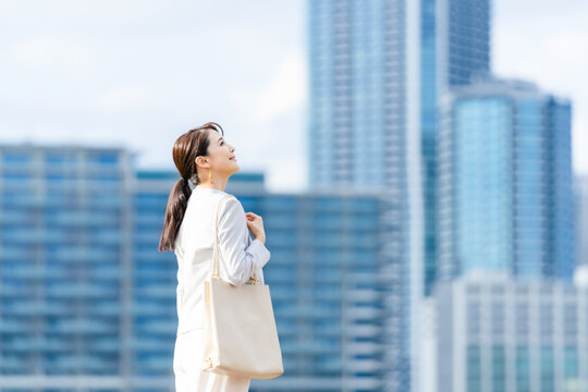 ビジネスウーマン、女性、笑顔、都市、キャリアウーマン、OL、ビル、高層ビル、都会、仕事、ビジネス、1人、働く、会社員、若い、20代、30代、日本人、美人、上半身、爽やか、立つ、微笑、微笑み、かわいい、背景、ライフスタイル、営業、外回り、オフィスカジュアル、スーツ、通勤、出勤、オフィスビル、楽しい、うきうき、おだやか、さわやか、成功、希望、光、晴れ、外勤、満足、チャレンジ、挑戦、見上げる、充実、キャ