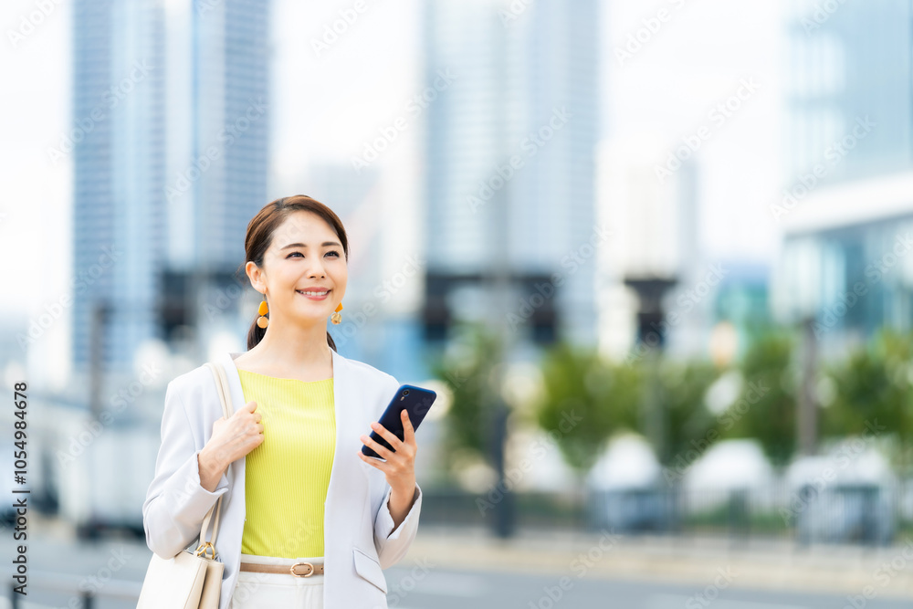 Poster スマホ、スマートフォン、女性、ビジネスウーマン、モバイル、アプリ、配車、屋外、タクシー、通信、街、都市、道路、道案内、ルート検索、検索、笑顔、カメラ目線、街角、歩く、歩行者、gps、ナビ、ナビゲーショ