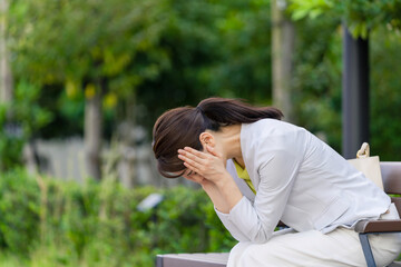 落ち込む、女性、ビジネスウーマン、ベンチ、失敗、頭痛、片頭痛、悩み、躊躇、絶望、イライラ、OL、キャリアウーマン、全身、座る、公園、ビジネス、仕事、20代、30代、若い、働く、会社員、日本人、美人、ライフスタイル、営業、外回り、オフィスカジュアル、苦しい、怒り、考える、めまい、思考、ストレス、神経質、モヤモヤ、狼狽、ショック、後悔、焦燥感、疲れ、心配、不安、残念、無念、問題、トラブル、悲しみ、人物