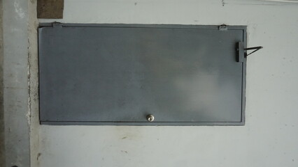 The door of a gray room at the back of a building
