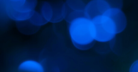 Blurred image of blue bokeh lights against a dark backdrop. Dark bokeh photo with blurred light,...