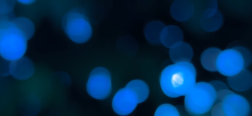 Blurred background with out-of-focus blue lights creating a bokeh effect. Dark bokeh photo with blurred light, Background for banner.