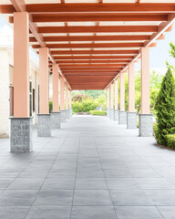 Elegant walkway featuring a wooden trellis and stone columns in a tranquil garden setting