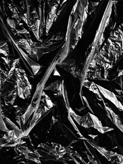 Wrinkled plastic wrap texture on a black background
