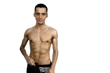 Fototapeta premium Young attractive man with athletic body posing in studio.