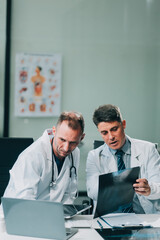 Fototapeta premium Group of medical practitioners working together and analyzing medical scan in the hospital