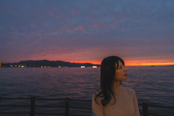 夕暮れの海にいる女性