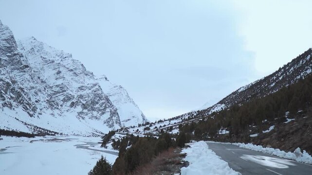 Road going through the snowy mountains in Jispa, Himachal Pradesh, India. Road near river at winter frozen day in Lahaul. Winter holidays and travel concept