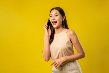 Asian beautiful woman making phone call in isolated yellow background.