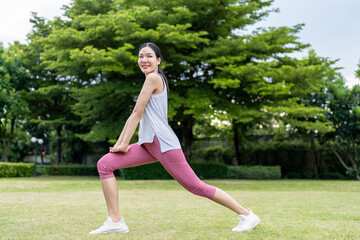 Asian woman stretching body before exercise in morning at public park. 