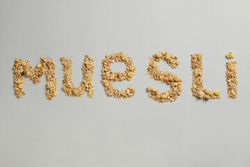 The word muesli from muesli granules on a gray background