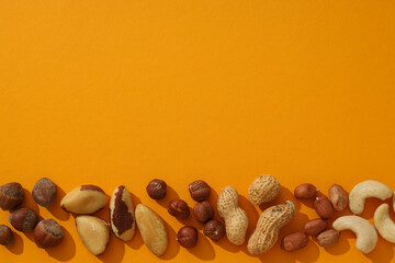 Assortment of different nuts on an orange background