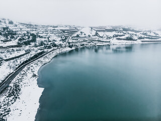 Winter Wonderland - A foggy day over a blue lake surrounded by snowy hills in Northern Israel