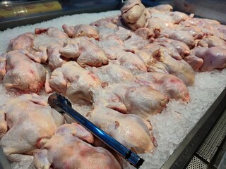 Fresh chickens displayed on ice in a supermarket. Perfect for roasting or grilling, ensures quality and freshness. Ideal for advertising, menus, or culinary blogs, highlighting premium meat