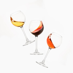 Wine of different colors, varieties splashes in stemware.