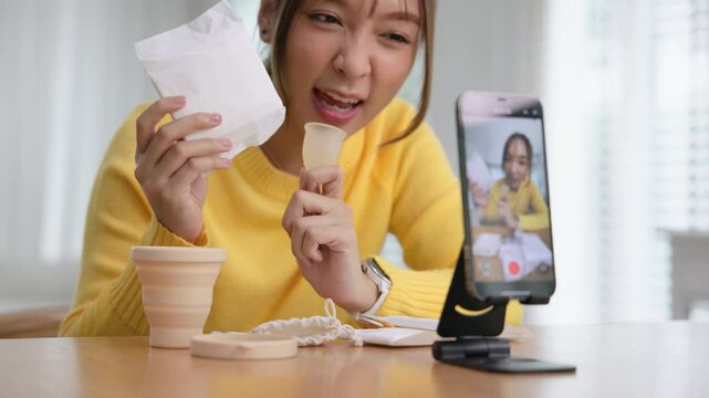 Go green zero waste retail store live stream selfie talk on phone eco health care product reduce pad issue. Asia people young woman record viral vlog home video on reel happy side hustle social media.