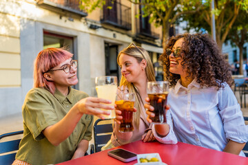 Women toasting and celebrating together sitting on an outdoor bar