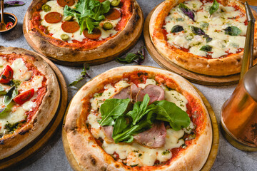 Top view of various neapolitan pizzas on grey stone table
