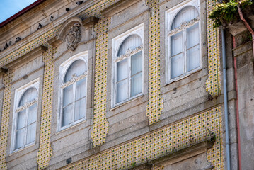 Traditional yellow tiles on the facade of an old house in the center of Braga in Portugal