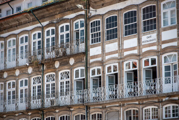 Traditional Portuguese facade with many windows at a house at Largo do Toural square in Guimaraes, Portugal