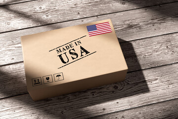 Cardboard box with made in USA label resting on wooden floor