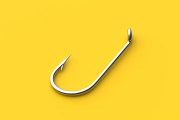 Shiny metallic fish hook lying on a yellow background