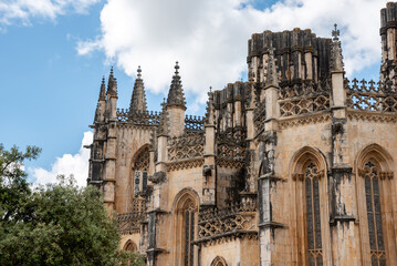 Fototapeta premium Picturesque detail of the facade of medieval Santa Maria da Vitoria monastery in Batalha, a manueline gothic masterpiece, view on the unfinished chapel