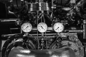 Detailed view of three pressure gauges on an industrial machinery in a historic power station