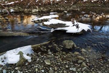 Remnants of ice and snow on the course of the Juhyne River. Eastern Moravia. Czechia. 