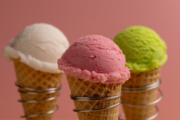 A ball of ice cream in a waffle cone, an assortment of flavors, raspberry, pistachio, mint, strawberry