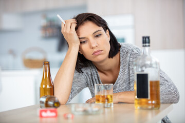 Fototapeta premium depressed woman at home smoking and drinking