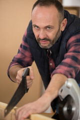 a middle aged man using handsaw