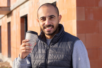 portrait of young bearded worker taking break
