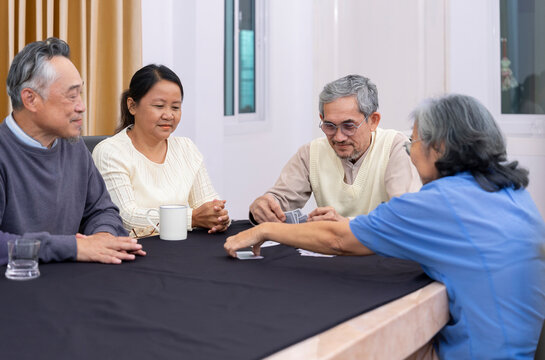 playful asian senior friends meet and play cards game together,concept of elderly people activity entertainment,recreation,encourages social interaction,help memory retention