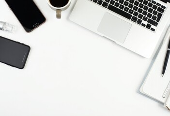 Flat-lay image of a desk setup with a laptop, smartphone, coffee cup, and productivity tools