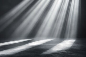 Dramatic spotlight beams illuminate a dark stage with a concrete floor.