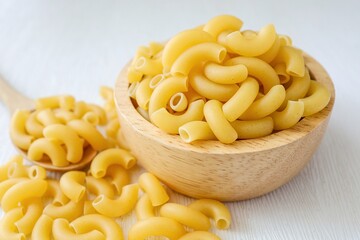 Raw uncooked macaroni in a wooden bowl on a white background	