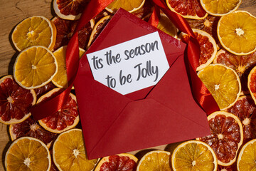 Christmas handmade wreath made of dried slices of orange and grapefruit with red envelope and paper...