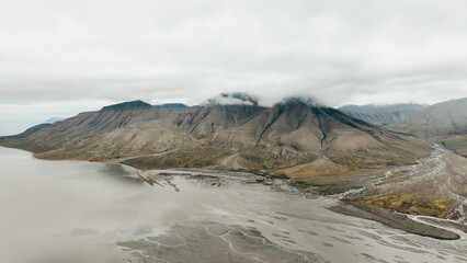 Stunning aerial view of Svalbards rugged landscape with distant mountains and water body