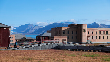 Exploring the abandoned buildings of Pyramiden in Svalbard under clear blue skies