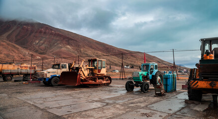 Fototapeta premium Exploring the abandoned machinery and vehicles at Pyramiden in Svalbard under overcast skies