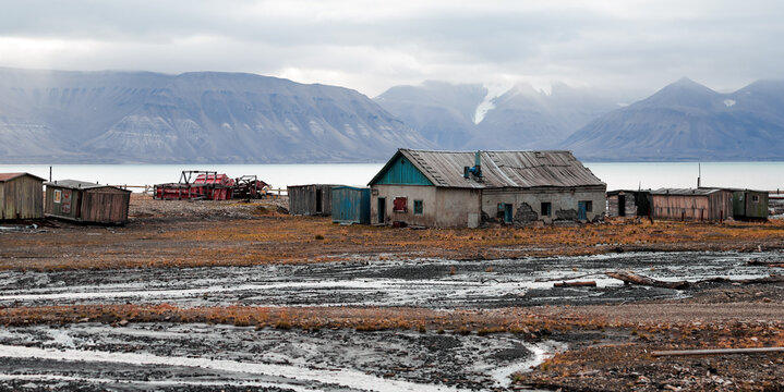 Exploring the abandoned buildings of Pyramiden in Svalbard under a cloudy sky