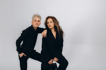 a guy and a girl in black suits on a white background