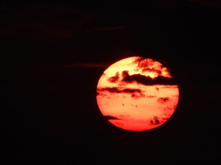 extremely zoomed sun at the sunset by the sea