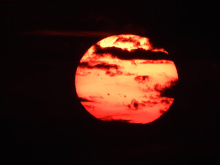 extremely zoomed sun at the sunset by the sea