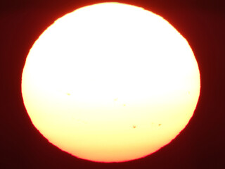 extremely zoomed sun at the sunset by the sea