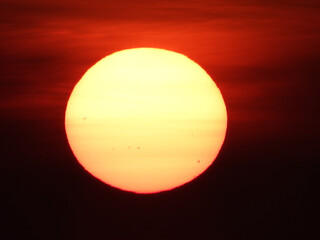 extremely zoomed sun at the sunset by the sea