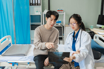 medicine, healthcare and people concept - doctor talking to male patient at bed in hospital.